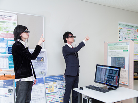 【写真2】電通大での研究室オープンハウスでの様子。開発したスマートグラスインタフェースを実演している。