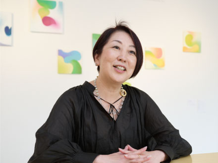 一般社団法人ELAB理事で「未来を描くプログラム」のディレクター兼講師を務めるアートプロデューサーの長谷部貴美さん。株式会社ホワイトシップでは代表取締役を務める。長谷部さんの後ろに展示されているのは谷澤邦彦さんの作品。